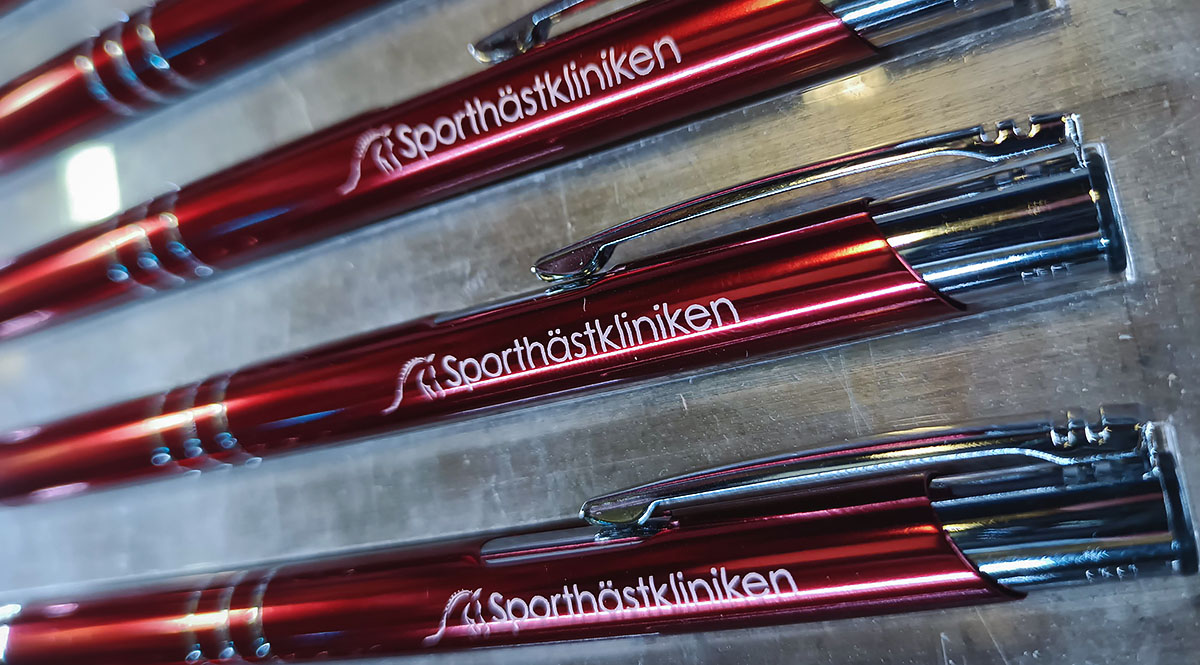 Graverade metallpennor i färgen Burgundy, graverade med Sporthästklinikens logotyp - Reklamhuset RINK